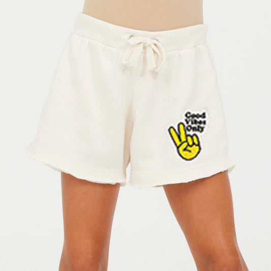 Light cream shorts with 'good vibes only' with a peace sign decal on the shorts