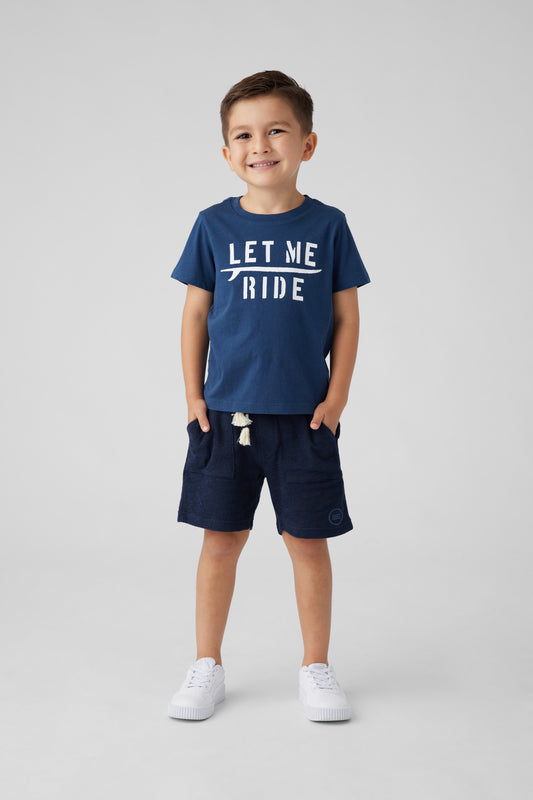 Model image, navy t-shirt with 'Let me ride' printed on the front. Surf board under 'Let Me'